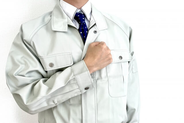 作業服を着た胸に手を当てる男性
