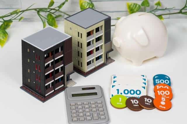 ミニチュア建物と電卓と貯金箱