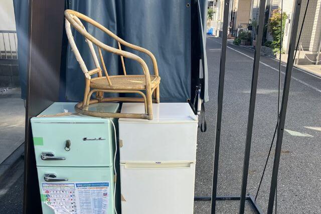 古い冷蔵庫と木製イスの屋外配置