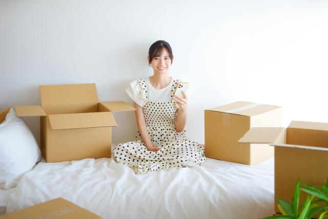 段ボールに囲まれた白い服の女性